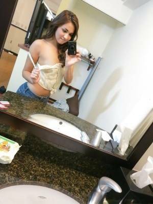 Sassy brunette stripping in front of the mirror and making selfies on adultfans.net