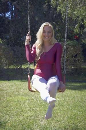 Busty blonde Hayley Marie Coppin strips bodysuit and white pantyhose outdoors on adultfans.net