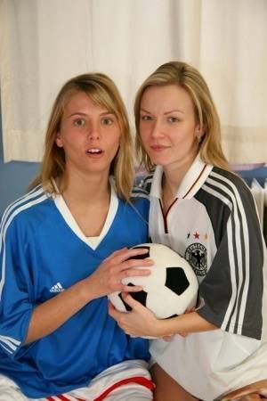 Cute teen girls go lesbian after trying on soccer outfits on a bed on adultfans.net