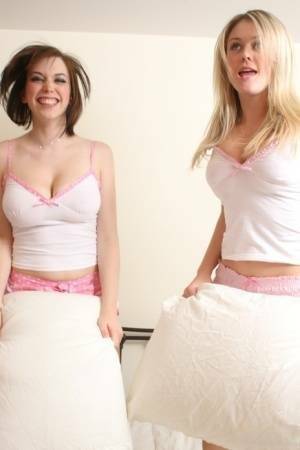 Young blonde Brooke Little and a girlfriend expose their big naturals on a bed on adultfans.net