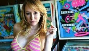 Brett Rossi fingers her pussy in striped OTK socks atop pinball machine on adultfans.net