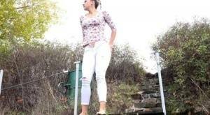 Mature Bianca pulls down her white pants to take a steaming pee outside on adultfans.net