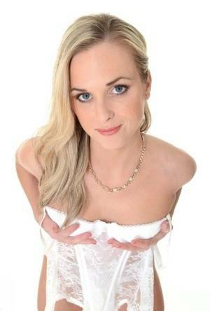 Pretty blonde Vinna Reed takes off white lingerie and matching hosiery on adultfans.net