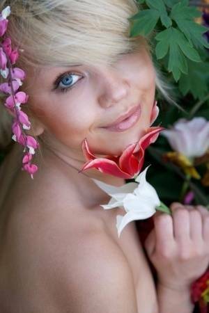 Cute young blonde Iveta poses in the nude while in a garden on adultfans.net