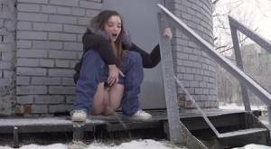 White girl pulls down her jeans to pee in the snow behind a building on adultfans.net