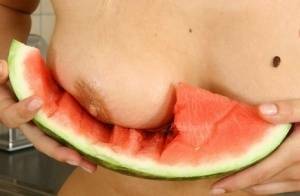 Blonde vixen Flower undressing in the kitchen to eat melon with bare big tits on adultfans.net