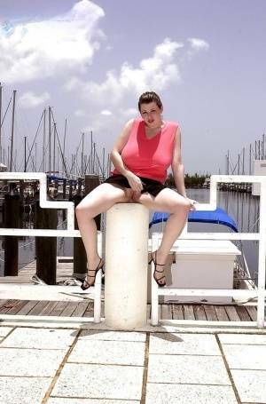 Plump pornstar Desirae flashing her huge tits and upskirt pussy on boat dock on adultfans.net