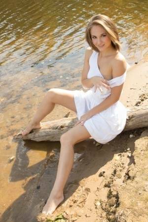 White teen of legal age shows off her naked body on a log that's beached on adultfans.net