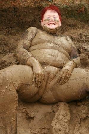 Older redhead Valgasmic Exposed rolls around in a mud pit while totally naked on adultfans.net