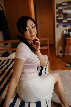 Slender mature Japanese woman Emiko Koike bends over to pose in white dress - Japan on adultfans.net