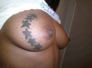 Ebony amateur takes self shots of her big tattooed boobs and bald vagina on adultfans.net