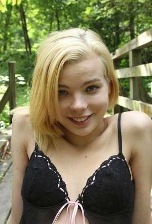 Cute teen amateur Sophia Kitten posing in nude in knee high socks in woods on adultfans.net