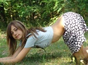 Shapely young teen in tiny t-shirt and short skirt posing outdoors on adultfans.net