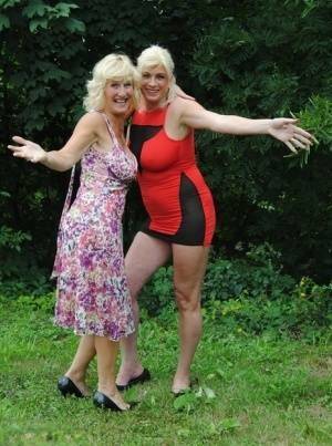 Mature lesbian Dimonty and GF cover their naked bodies in see thru raincoats on adultfans.net
