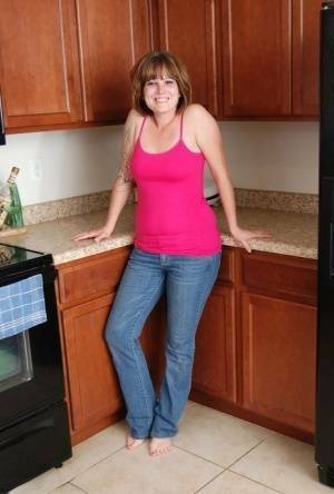 Redhead amateur Misty B gets completely naked in her kitchen on adultfans.net