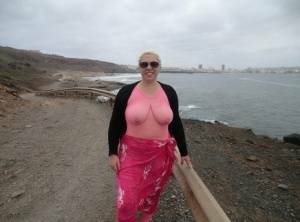 Aged lady Barby looses her big tits from a crotchless bodystocking by the sea on adultfans.net