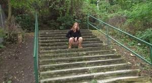 Natural redhead Chrissy Fox squats for a pee on a set of public steps on adultfans.net