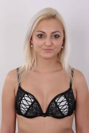 Blonde amateur Sarka stands clothed and then totally naked during solo action on adultfans.net