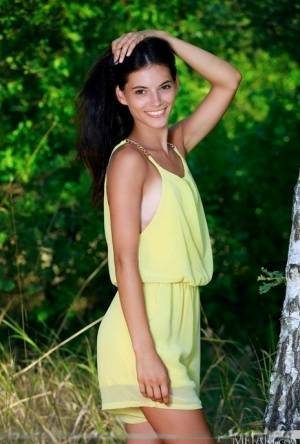 Nice teen Aleksandrina exposes her tan lined body by a hardwood tree on adultfans.net