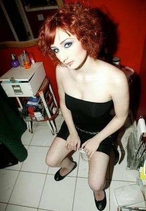 Pale redhead Violet Monroe gets naked in flat shoes while in a bathroom on adultfans.net