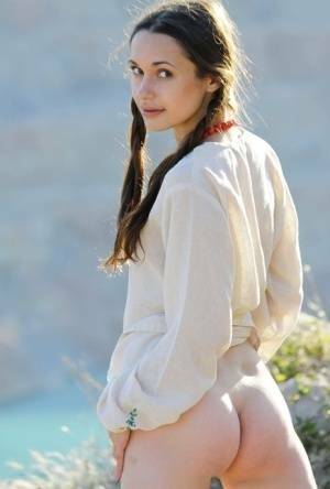 Teen model Ilona B poses nude in pigtails high above ocean waters on adultfans.net