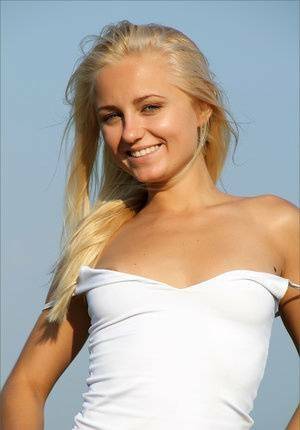 Blonde teen gets totally naked to for a solo shoot up on a hilltop on adultfans.net