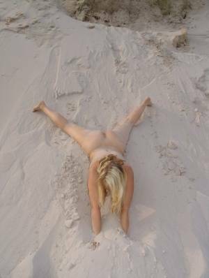 Blonde amateur Sweet Susi gets totally naked on a sandy bank by herself on adultfans.net