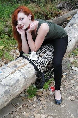 Young redhead chick Nicci Vice showing off tits and ass in the woods on adultfans.net