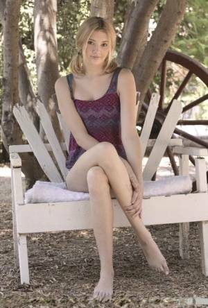 Teen first timer Lena Anderson vaunts her lithe body under a tree outside on adultfans.net