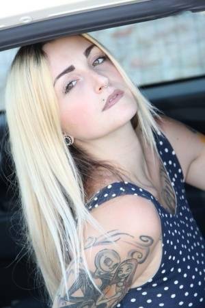 Tattooed girl Medusa Blonde shows her bare feet and ass while in a car on adultfans.net