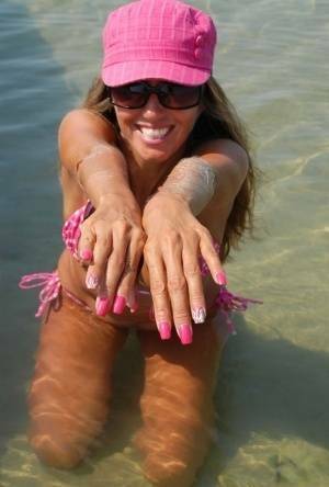 Amateur model Lori Anderson shows her hairy arms while wearing a bikini on adultfans.net