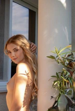 Young blonde Chanel Fenn shows her sexy ass while getting naked in a garden on adultfans.net