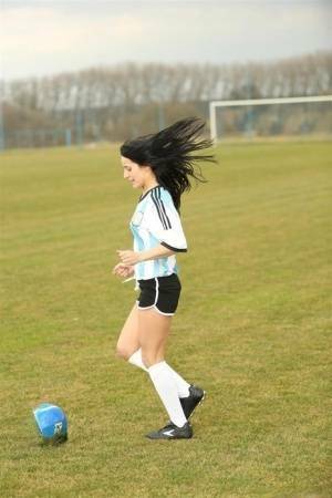 Barely legal soccer player removes her uniform before masturbating on a bench on adultfans.net