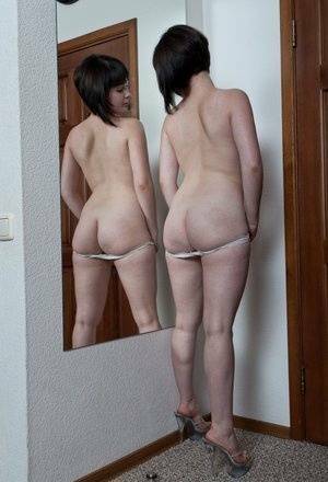 White teen with a full bush admires herself in mirror while disrobing on adultfans.net