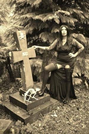 Goth girl Barby Slut bares her big tits and twat atop a casket in the woods on adultfans.net