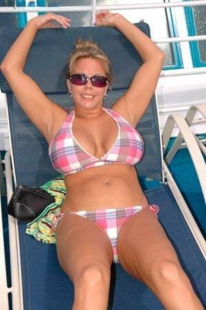 Hugely busty Amber Lynn Bach doffs her bikini to spread her legs wide nude on adultfans.net