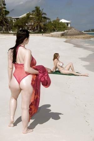 Fervent lesbians stripping nude and playing with dildos on the beach on adultfans.net