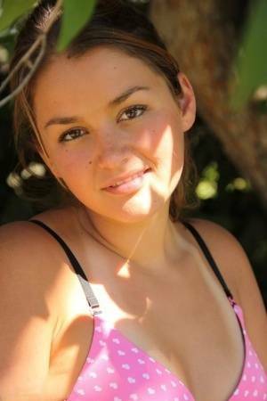 Petite amateur Allie Haze shows her tan lined body in the shade of a tree on adultfans.net