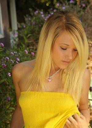 Blonde amateur Teagan bares her A-cup tits in a yard as she gets totally naked on adultfans.net