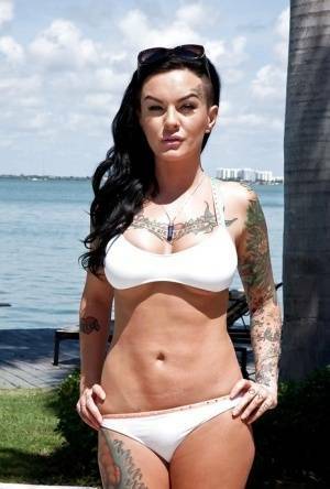 Tattooed whore Lolo Luscious exposing big hooters in swimming pool on adultfans.net