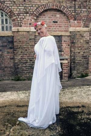 Blonde granny Savana models non nude in a long white gown on adultfans.net