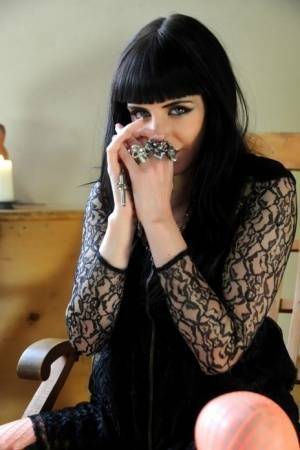 Goth babe Sam Bentley carves a pumpkin while topless in see thru pantyhose on adultfans.net