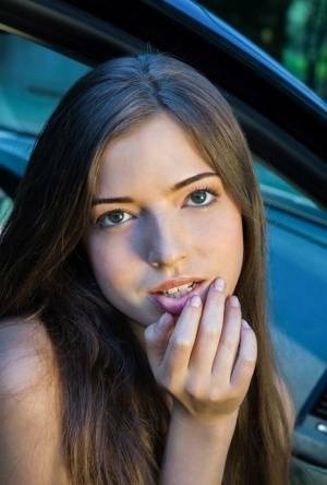 Beautiful teen girl models in the nude on passenger seat of car with door open on adultfans.net