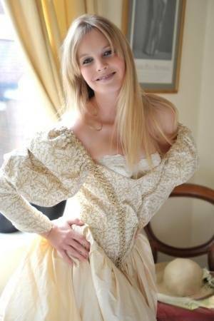 Blonde girl Rose takes off her petticoat to model in a girdle and nylons on adultfans.net