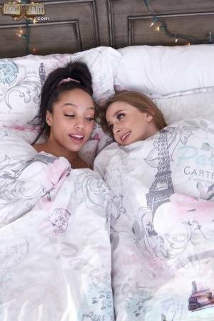 Interracial lesbians lick assholes and pussies on a bed in sport socks on adultfans.net