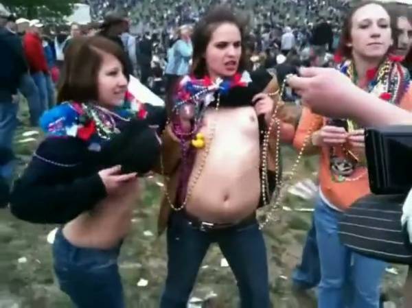 Group gathers in park as woman lets her top be lifted off by companions on adultfans.net
