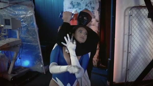 Brunette superheroine in blue mask stripped down under surveillance on adultfans.net