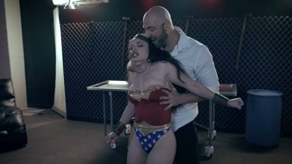 Brunette in Wonder Woman costume dominated in a shadowy institutional chamber on adultfans.net