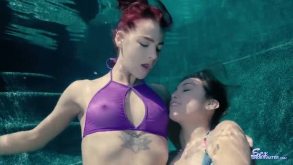 Redheaded woman receives cunnilingus underwater from a dark-haired partner on adultfans.net
