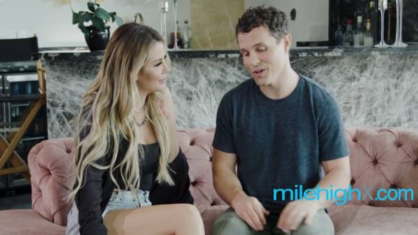 Blonde MILF rides young stud on pink sofa in luxurious modern kitchen on adultfans.net
